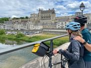 Verena on a bridge overlooking Château d'Amboise and the Loire River. The Renaissance castle towers above the historic town buildings.