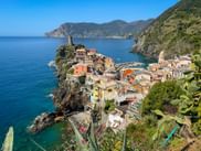 Vernazza village with colorful houses on rocky cliffs overlooking the Mediterranean Sea, with a small harbor and historic tower in Cinque Terre.