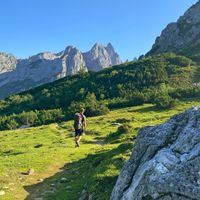 Wegmarkierung am Gosaukamm mit Wanderer und Bergen im Hintergrund