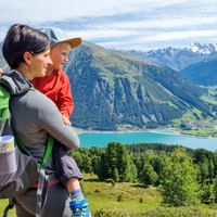 Hikers with a view of Lake Reschen in Italy