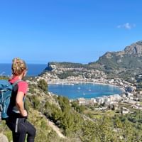 Hiker in front of the panoramic view of Port de Soller
