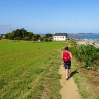 Wanderin am Weg entlang der Küste