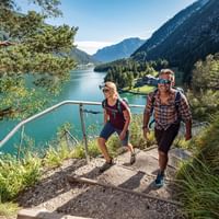 Happy travellers on a hiking trail with a view of the lake