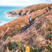 Wanderer am Küstenweg in Cornwall