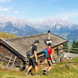 Hiker with mountain panorama and alpine hut