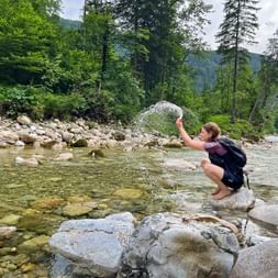 Wanderer kühlt sich am Bach ab