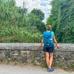 Wanderin auf der Steinbrücke am Jakobsweg