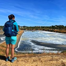 Wanderer mit Blick auf das Salzbecken in Fuesta an der Algarve