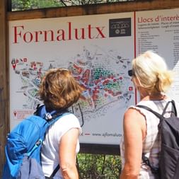 Two female hikers in front of the hiking board in Fornalutx