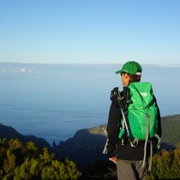 Wanderin auf Gipfel mit Blick aufs Meer und umliegende Berge auf Madeira