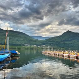 Seeblick mit Booten unter wolkigem Himmel