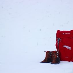 Hiking rucksack and hiking boots in the snow