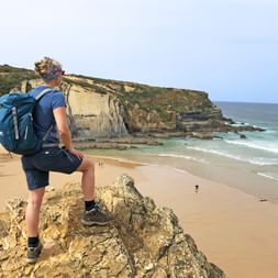 Hiker overlooking the sea on the Rota Vicentina