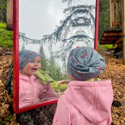 Child sees itself in the mirror at the adventure trail