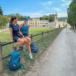 Two female hikers sit on the fence at Santa Maria Villa Mosconi Bertani