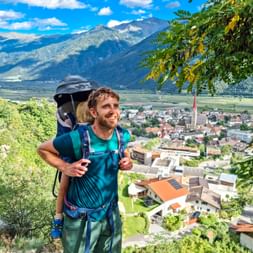 Hiker with back stretcher on the hiking trail in the municipality of “Schlanders”