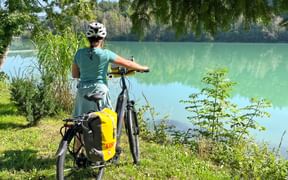 Cyclist standing by the river