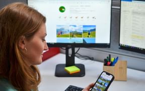 Woman with mobile phone in hand at her desk