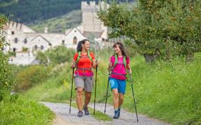 Hike of two women with Churburg Castle in the background