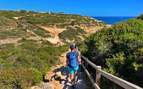Hiker on a path to a beach near Carvoeiro