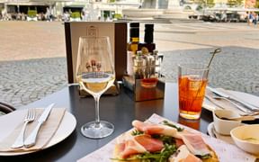 Hiking stop at Piazza Walther in Bolzano with an aperitif and a foccacia topped with air-dried ham and rocket salad