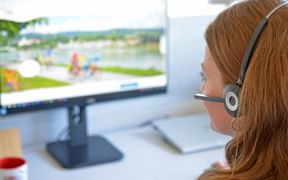 Employee with headset in front of computer