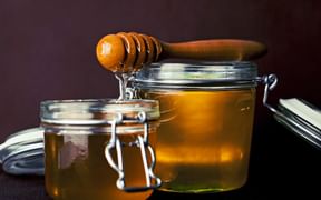 Honig in einem Einmachglas mit Honigschöpfer aus Holz