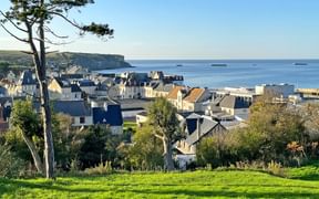 Blick auf die am Meer gelegene Gemeinde Arromanches-les-Bains