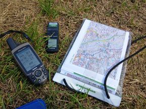 Karte, Diktiergerät und GPS-Gerät im Gras