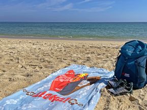 Backpack and beach towel by the sea