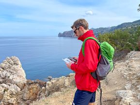 Wanderer liest die Reiseunterlagen auf Mallorca