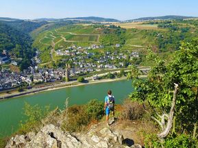 Wanderer mit Aussicht auf einen kleinen Ort am Rhein