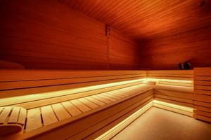 Innenraum der Palazzo del Garda Sauna mit Holzbänken, warmer Beleuchtung und Zedernholzwänden und -decke im traditionellen finnischen Stil.