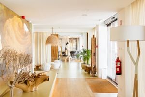 Moderne Hotellobby im Hotel Avenida Lagos mit weißen Wänden, Holzmöbeln, natürlichem Licht und zeitgenössischer Dekoration.
