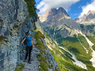 Hiker on the hiking trail through the imposing Brenta Dolomites