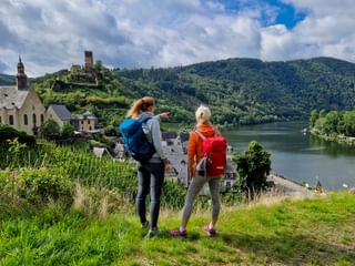 View of Metternich Castle and the Moselle with female hikers in the foreground