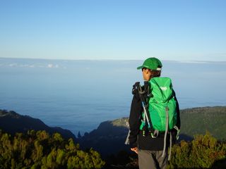Wanderin auf Gipfel mit Blick aufs Meer und umliegende Berge auf Madeira