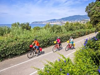 Drei Radfahrer auf Küstenradweg in Sanremo