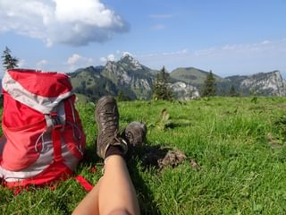 Wohlverdiente Pause in prächtiger Kulisse Wanderschuhe und Wanderrucksack vor Bergkulisse