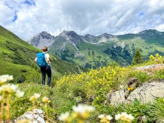 Hiker on the E5 and with a view of the mountain panorama of the Alps