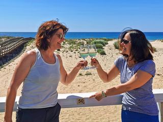Zwei Wanderinnen stoßen am Strand an