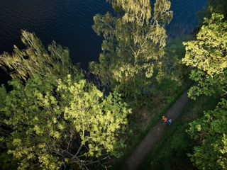 Bird's eye view of two hikers in nature, forest, lake