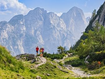 Hikers at the Vršič Pass with panoramic views of the mountains