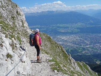 Hikers enjoy the stony hiking trail and the wonderful view down to Innsbruck