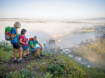 Hikers in front of Katz Castle in a misty morning mood