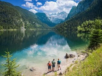Wanderer genießen den Dachsteinblick am Gosausee