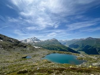 Bergpanorama mit Blick auf einen schneebedeckten Gipfel und den Surettasee
