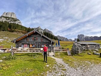 Hiker in front of an alpine hut on the way to Gosausee