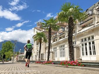 Hiker in front of the famous Kurhaus in Merano