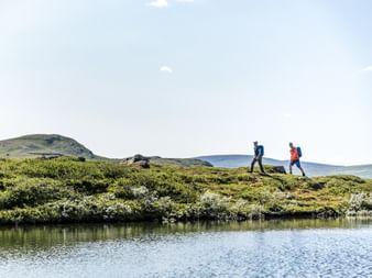 Zwei Wanderer wandern entlang des Fjords in Funasfjaellen